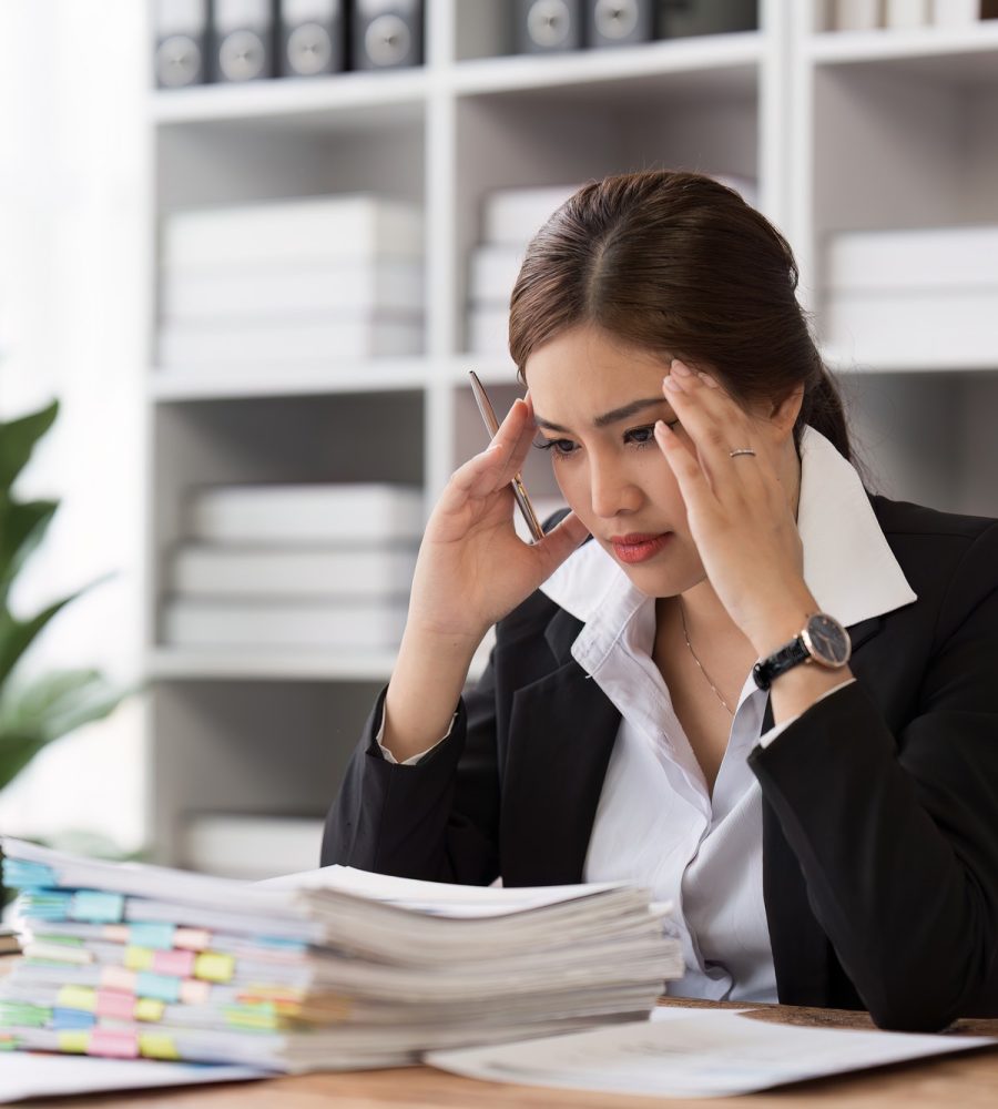 Employee feeling tired stressed with her work in the office, sad working woman overworked overtime